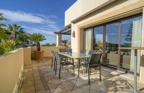 Main terrace with outdoor dining table beside the living room glazing